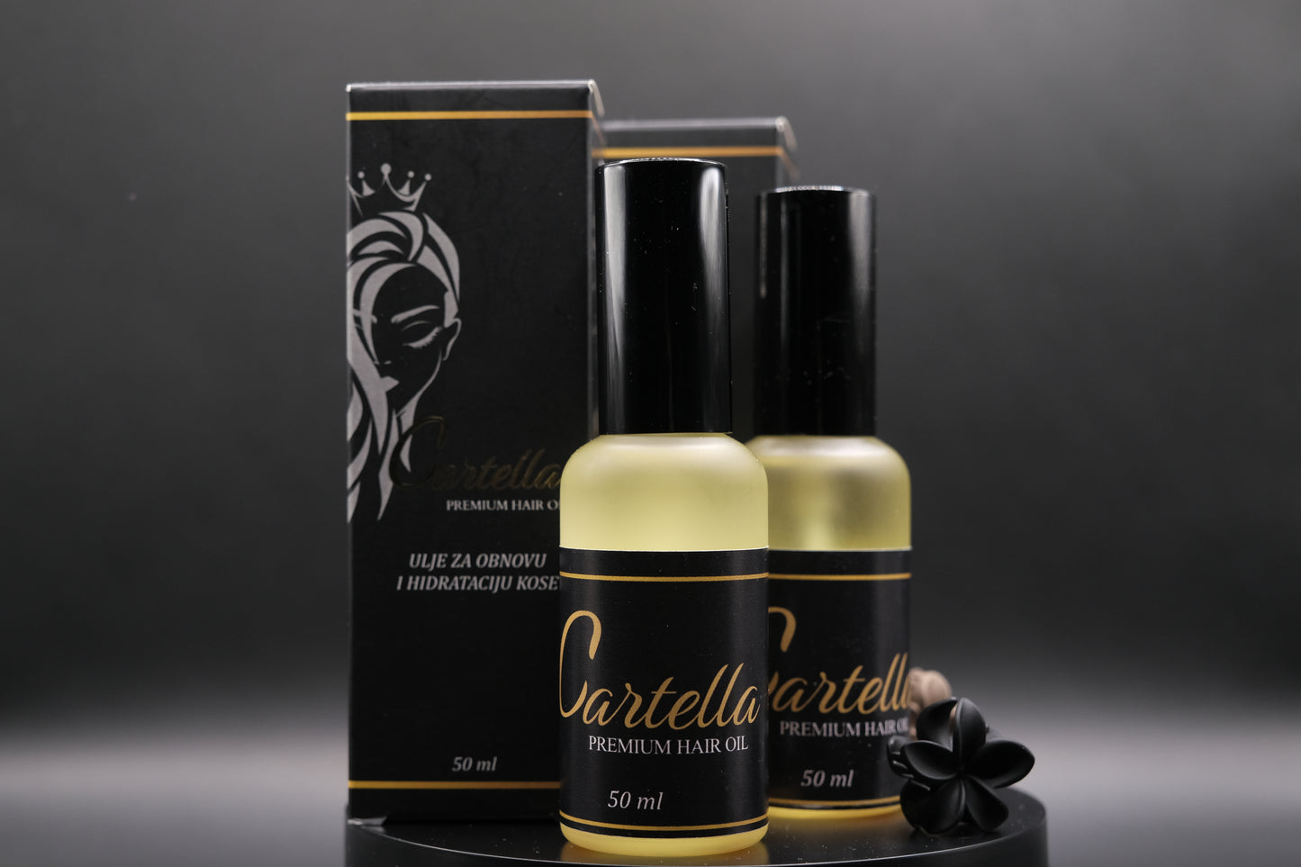 Cartella premium hair oil bottles and packaging on a dark background
