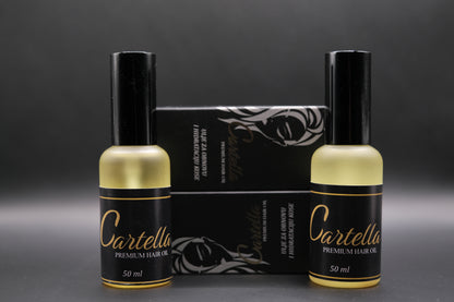 Two bottles of Cartella Premium Hair Oil with a black box in the background on a dark gray background