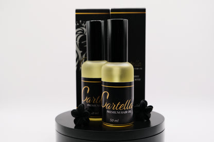 Two bottles of Dartella hair oil on a black stand with a black box in the background.